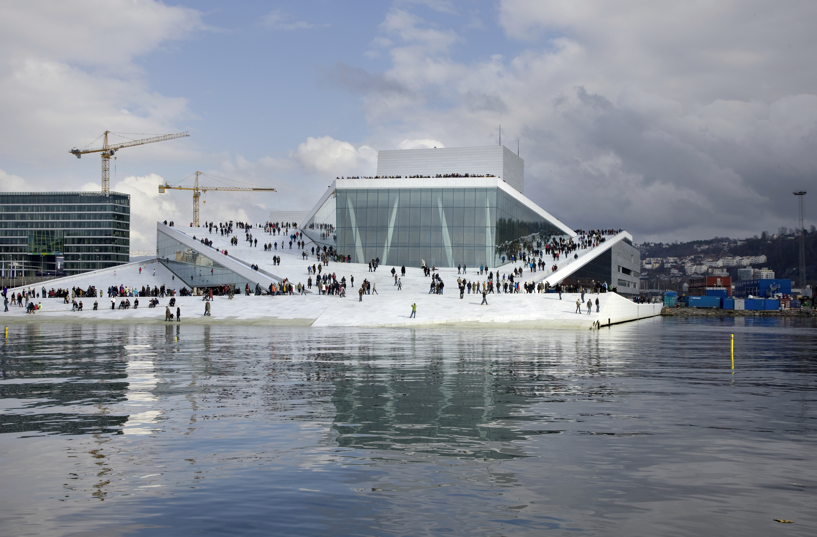 Le toit-terrasse de l’Opéra d’Oslo, situé en bordure de fjord, est entièrement accessible aux promeneurs pour devenir place publique. Pas besoin de tickets pour s’y rendre donc contrairement aux trois salles de concert qu’abrite le bâtiment. (Architecte : Snøhetta architects)